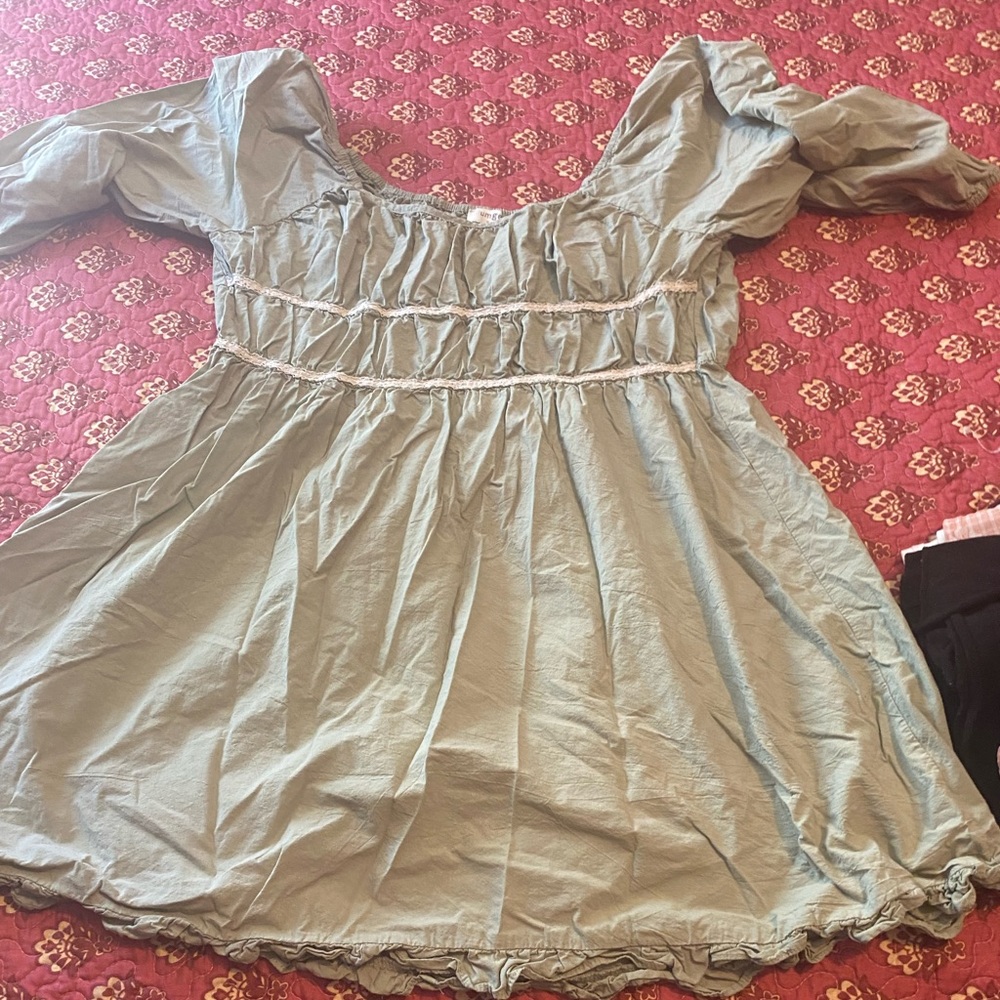 Flowy pastel green dress with white embellishment, knee length